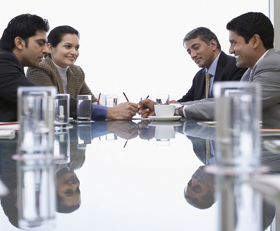 A group of four businesspeople talking at a table